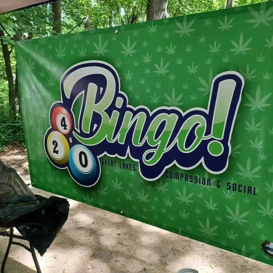 Bingo-themed banner with pool balls and text on a green background with leaf pattern, outdoors.